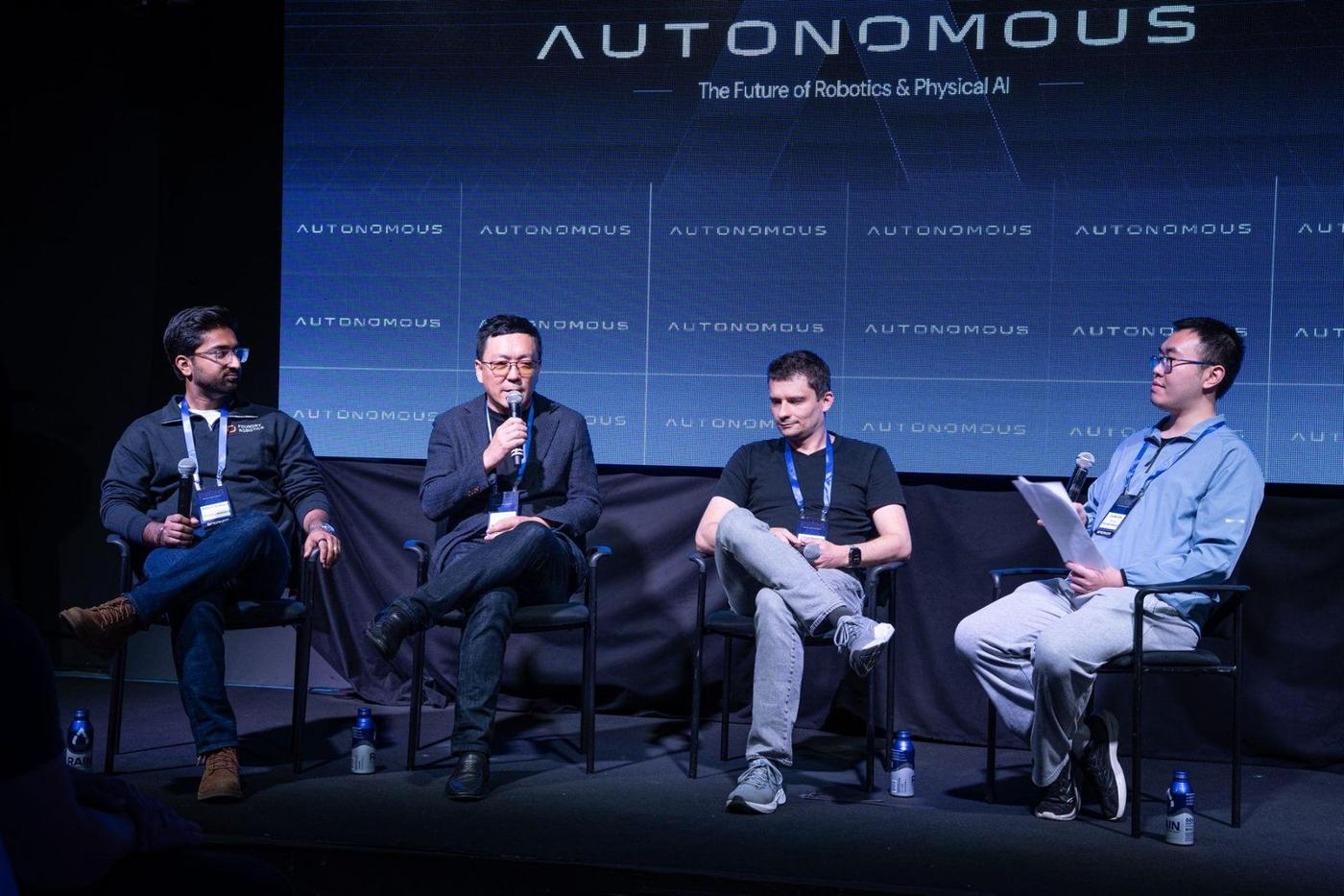 Junfan Zhu moderating a four-person panel on stage at AUTONOMOUS 2026